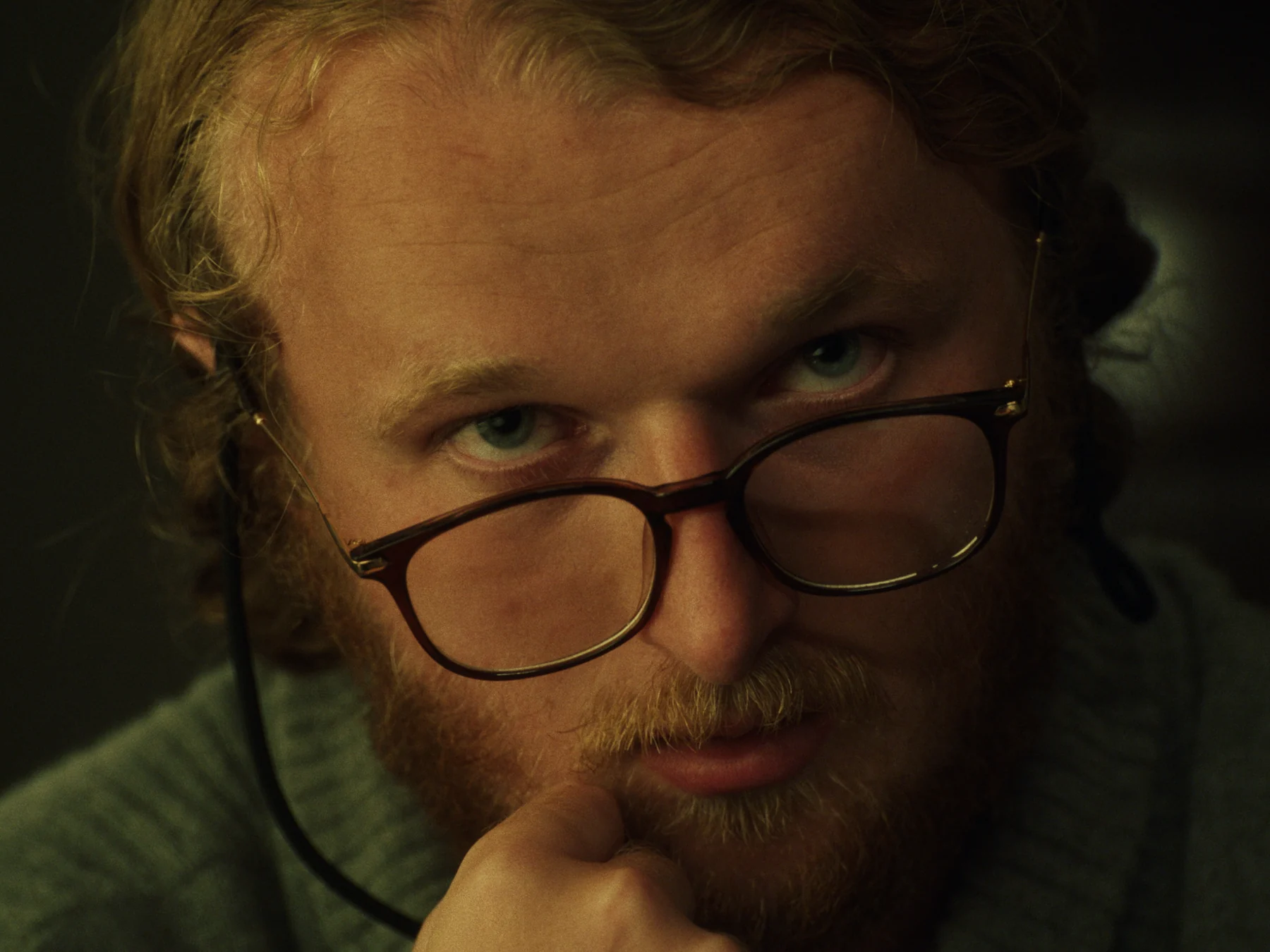 Oliver Woolf as Chester, looking over his lowered glasses