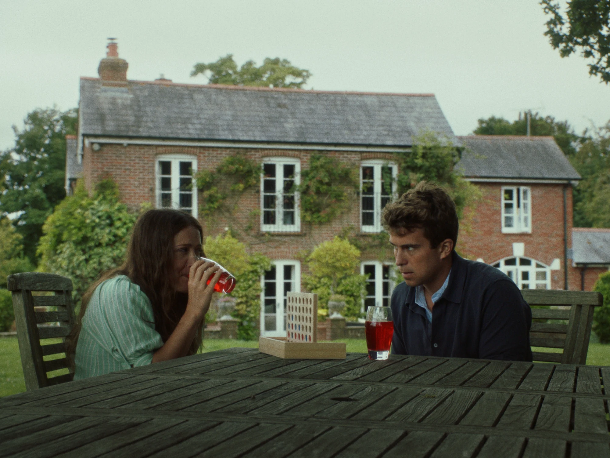 Liam and Mel seated at a garden table outside the cottage