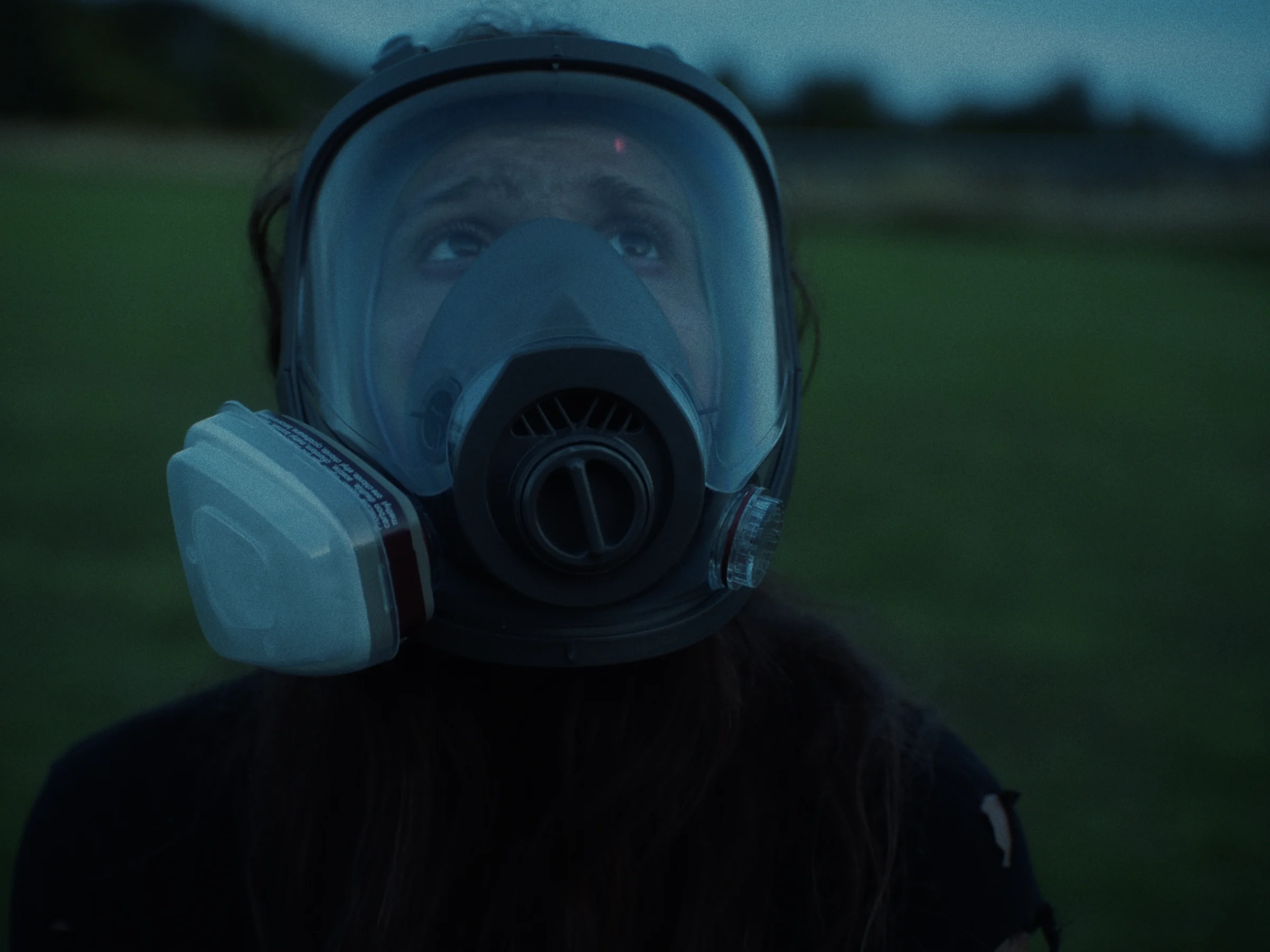 Mel wearing a full-face respirator in the English countryside